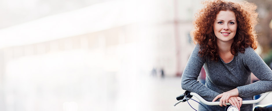 mulher apoiada em uma bicicleta