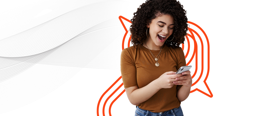 Mulher manuseando seu celular com expressão alegre demonstrando sua satisfação e o sentimento de ter tudo no mesmo ambiente por conta de uma estratégia de marketing digital e mídias sociais bem elaborada.